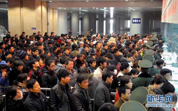 China's railways will carry 235 million passengers during the 40-day Spring Festival travel rush, up 6.1 percent year-on-year. In the picture, people are queuing for tickets at the Tianjin Railway Station on Jan. 5.