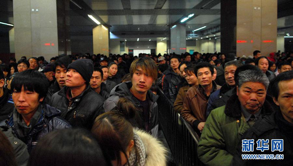 China's railways will carry 235 million passengers during the 40-day Spring Festival travel rush, up 6.1 percent year-on-year. In the picture, people are queuing for tickets at the Tianjin Railway Station on Jan. 5.