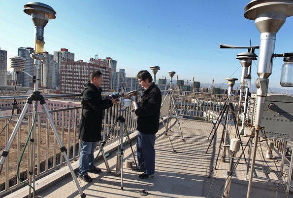 China National Environment Monitor Center (CNEMC) workers inspect PM2.5 - airborne pollutants smaller than 2.5 microns in diameter - monitoring equipment in Beijing on Jan 4, 2012. [CFP] 