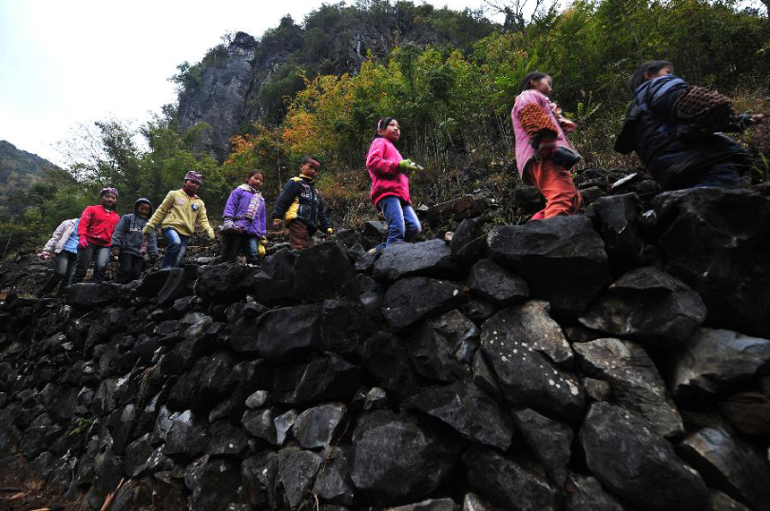Children walk along the mountain road on their way to school at Minxin Village of Mashan County in southwest China's Guangxi Zhuang Autonomous Region, Jan. 6, 2012. Every day, they have to leave home very early in the morning and climb over hills for hours to go to school.
