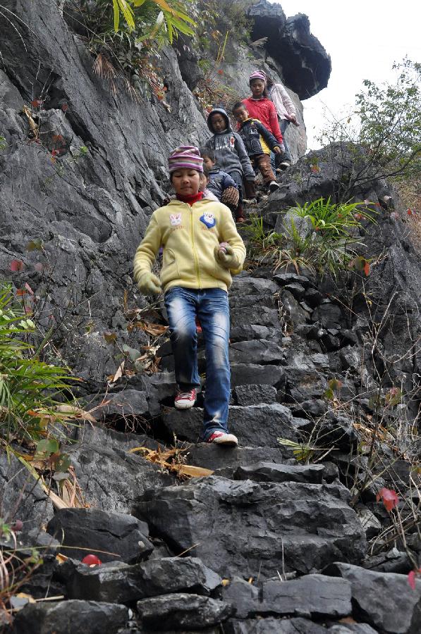Children walk along the mountain road on their way to school at Minxin Village of Mashan County in southwest China's Guangxi Zhuang Autonomous Region, Jan. 6, 2012. Every day, they have to leave home very early in the morning and climb over hills for hours to go to school.