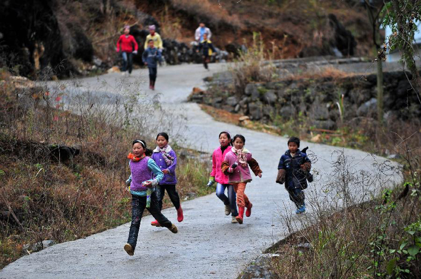 Children run to school when hearing the bell of their school at Minxin Village of Mashan County in southwest China's Guangxi Zhuang Autonomous Region, Jan. 6, 2012. Every day, they have to leave home very early in the morning and climb over hills for hours to go to school. 