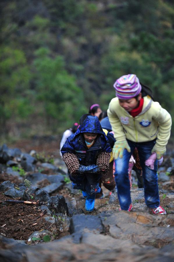 Children walk along the mountain road on their way to school at Minxin Village of Mashan County in southwest China's Guangxi Zhuang Autonomous Region, Jan. 6, 2012. Every day, they have to leave home very early in the morning and climb over hills for hours to go to school. 