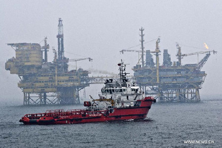 A ship moves near the platform B in Penglai 19-3 oilfield at north China's Bohai Bay, in this file photo taken on July 15, 2011. [Xinhua]