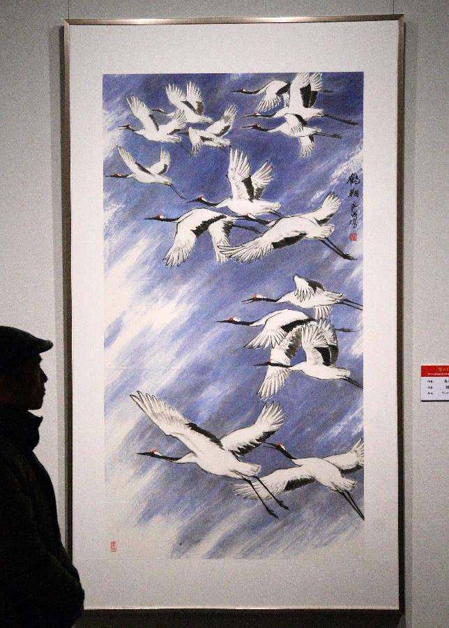 A visitor appreciates a painting at the Jiangsu Traditional Chinese Painting Institute Art Exhibition at Jiangsu Provincial Art Museum in Nanjing City, east China's Jiangsu Province, Jan. 13, 2012. (Xinhua/Wang Xin)