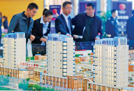 People in Jiujiang, East China's Jiangxi province, visit a housing project display. Continued purchase restrictions and tight credit signal a difficult year for developers. [China Daily]