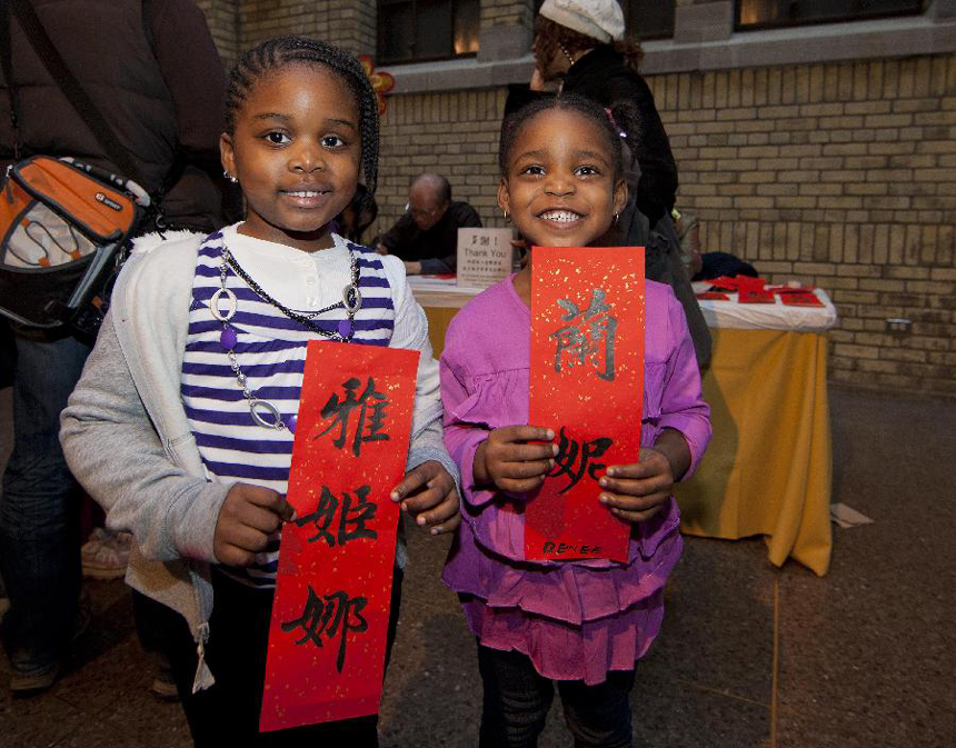Two girls show their Chinese names written in Chinese calligraphy during a Chinese New Year celebrating event held at the Royal Ontario Museum in Toronto, Canada, Jan. 15, 2012.