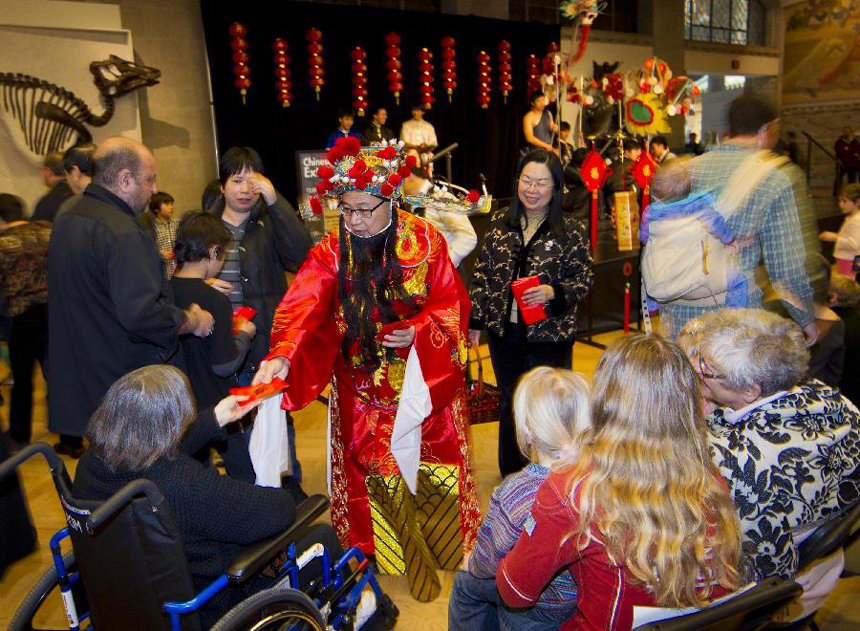 A man dressed as a Chinese God of Wealth hands out lucky money during a Chinese New Year celebrating event held at the Royal Ontario Museum in Toronto, Canada, Jan. 15, 2012. 