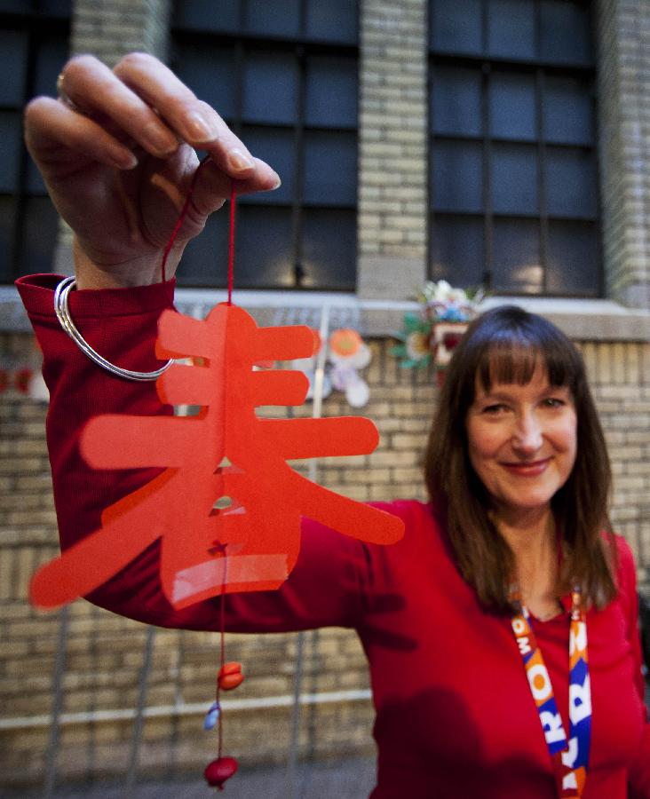A woman shows a piece of paper-cut work made by herself during a Chinese New Year celebrating event held at the Royal Ontario Museum in Toronto, Canada, Jan. 15, 2012.