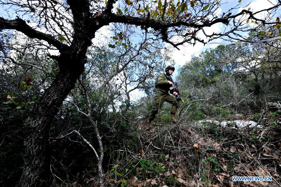 A soldier of Israeli Defense Forces (IDF) takes part in a drill to strengthen sergeants' practical ability to command on hills near Moshav Amikam, North Israel, on Jan. 18, 2012. [Yin Dongxun/Xinhua]