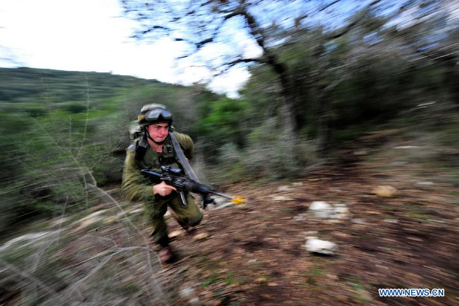 A soldier of Israeli Defense Forces (IDF) takes part in a drill to strengthen sergeants' practical ability to command on hills near Moshav Amikam, North Israel, on Jan. 18, 2012. [Yin Dongxun/Xinhua] 