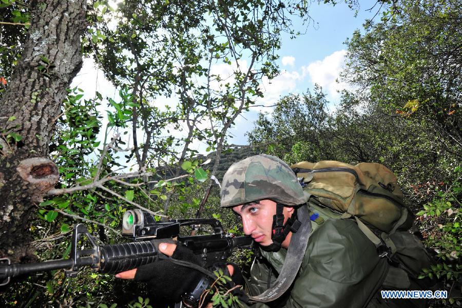 A soldier of Israeli Defense Forces (IDF) takes part in a drill to strengthen sergeants' practical ability to command on hills near Moshav Amikam, North Israel, on Jan. 18, 2012. [Yin Dongxun/Xinhua] 