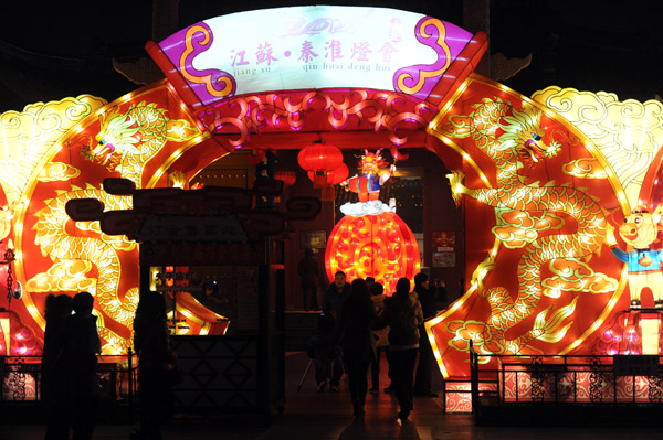 Nanjing residents enjoy the festive lantern decorations at the Gate of China area along the banks of the Qinhuai River in Nanjing, capital city of East China's Jiangsu province, on Jan 19, 2012. More than a hundred large sets of lantern scenes and over 400,000 individual lanterns will dress up the banks of the Qinhuai River during the fair, Jan 19 to Feb 9.
