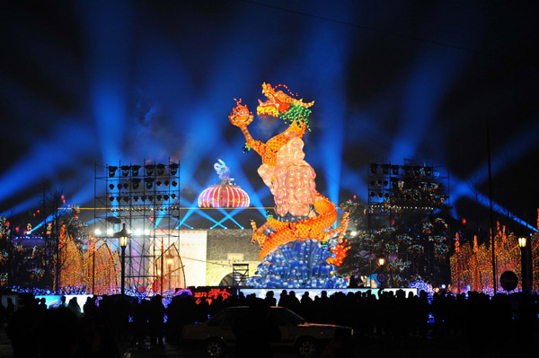 Nanjing residents enjoy the festive lantern decorations at the Gate of China area along the banks of the Qinhuai River in Nanjing, capital city of East China's Jiangsu province, on Jan 19, 2012. More than a hundred large sets of lantern scenes and over 400,000 individual lanterns will dress up the banks of the Qinhuai River during the fair, Jan 19 to Feb 9.