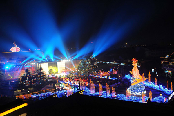 Nanjing residents enjoy the festive lantern decorations at the Gate of China area along the banks of the Qinhuai River in Nanjing, capital city of East China's Jiangsu province, on Jan 19, 2012. More than a hundred large sets of lantern scenes and over 400,000 individual lanterns will dress up the banks of the Qinhuai River during the fair, Jan 19 to Feb 9.