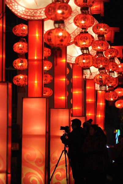 Nanjing residents enjoy the festive lantern decorations at the Gate of China area along the banks of the Qinhuai River in Nanjing, capital city of East China's Jiangsu province, on Jan 19, 2012. More than a hundred large sets of lantern scenes and over 400,000 individual lanterns will dress up the banks of the Qinhuai River during the fair, Jan 19 to Feb 9.