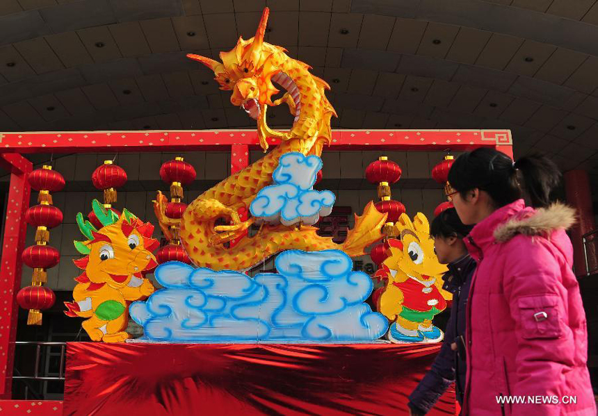 People walk past a dragon lantern in Shenyang, capital of northeast China's Liaoning province, Jan. 19, 2012. With the coming of the Spring Festival, the festal atmosphere has been spread all over Shenyang.