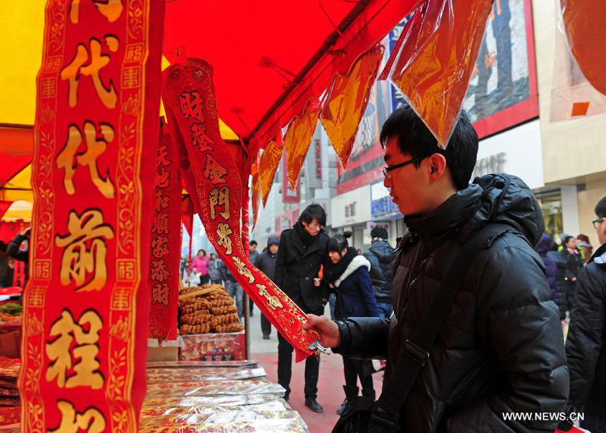 A citizen chooses spring festival scrolls in Shenyang, capital of northeast China's Liaoning province, Jan. 19, 2012. With the coming of the Spring Festival, the festal atmosphere has been spread all over Shenyang.