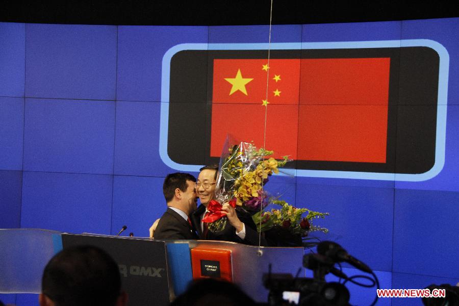 Senior Vice-President of Nasdaq Robert McCooey (L) presents a bouquet to Chinese Consul General Sun Guoxiang (R) at the opening bell ceremony of the Nasdaq Exchange in New York, the United States, on Jan. 20, 2012. The Nasdaq Exchange opened a bell-ring ceremony to mark the Chinese New Year, the Year of Dragon, on Friday. 