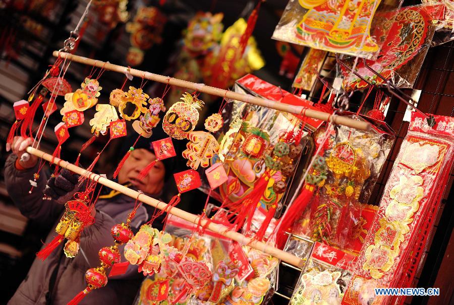 A shopkeeper displays festival ornaments in her shop at China Town in New York, the United States, Jan. 20, 2012. Shopkeepers sold various ornaments in their shops at China Town for the approaching Spring Festival. 