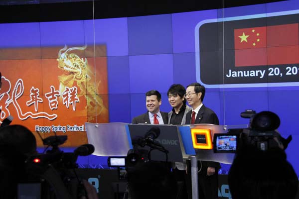 Chinese Consul General in New York Sun Guoxiang (C), pianist Lang Lang (R), and Nasdaq Senior Vice-President Robert McCooey (L) pose a playing piano gesture on the Times Square in front of the Nasdaq MarketSite screen for photos on Jan 20, 2012 in New York. [Xinhua] 