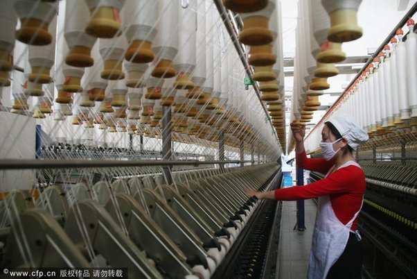 A female worker works at a textile company in Jiangsu's Nantong on December 11, 2011. [CFP]