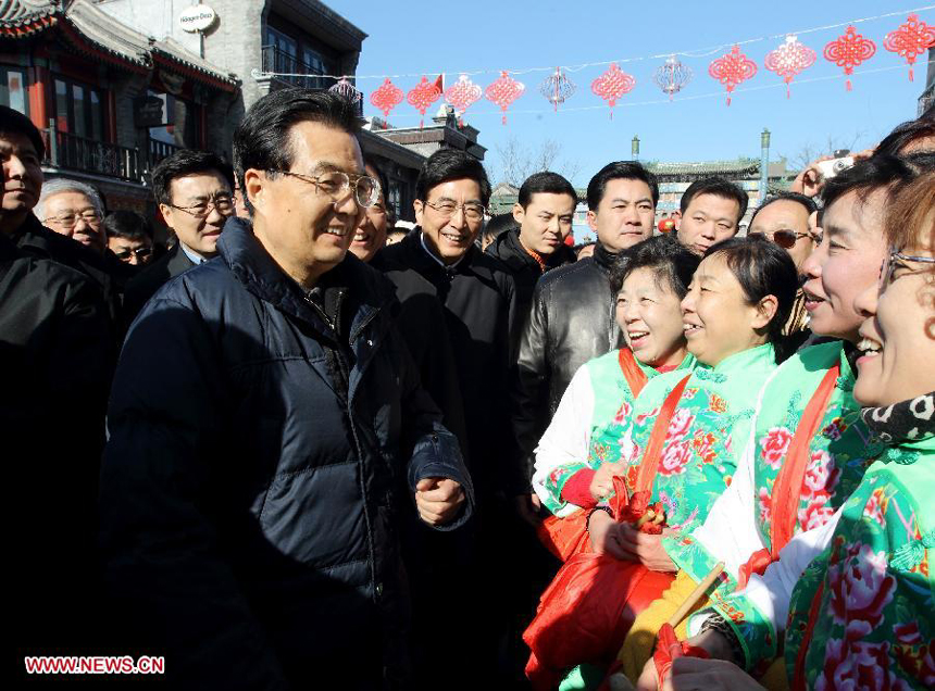 Chinese President Hu Jintao (L Front) talks with people as he visits the Qianmen shopping street in Beijing, capital of China, Jan. 22, 2012. Hu visited grassroots urban and rural areas in Beijing on Sunday, the eve of the Spring Festival, extending greetings to the people and celebrating with them the Chinese Lunar New Year. 