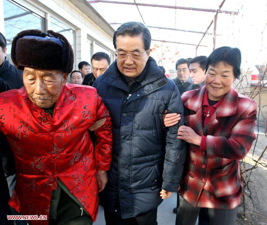 Chinese President Hu Jintao (C) walks out of the residence of army veteran Shao Qicheng (L) in Tianxianyu Village of the Huairou District in Beijing, capital of China, Jan. 22, 2012, after extending Chinese lunar New Year greetings to Shao and his family. Hu visited grassroots urban and rural areas in Beijing on Sunday, the eve of the Spring Festival, extending greetings to the people and celebrating with them the Chinese lunar New Year. 