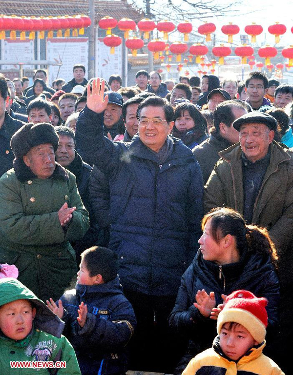 Chinese President Hu Jintao (C) greets the public as he watches 'Flower Is A Go-Between', a traditional opera, in Tianxianyu Village of the Huairou District in Beijing, capital of China, Jan. 22, 2012. Hu visited grassroots urban and rural areas in Beijing on Sunday, the eve of the Spring Festival, extending greetings to the people and celebrating with them the Chinese Lunar New Year. 