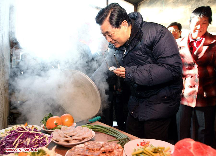 Chinese President Hu Jintao looks around in the kitchen of army veteran Shao Qicheng's home in Tianxianyu Village of the Huairou District in Beijing, capital of China, Jan. 22, 2012, examining the preparation of the family's Lunar New Year reunion dinner. Hu visited grassroots urban and rural areas in Beijing on Sunday, the eve of the Spring Festival, extending greetings to the people and celebrating with them the Chinese Lunar New Year.