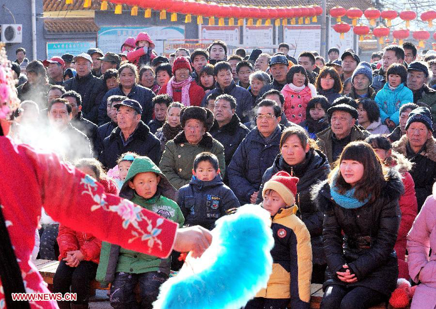 Chinese President Hu Jintao (3rd L 3rd row) watches 'Flower Is A Go-Between', a traditional opera, along with residents of Tianxianyu Village in the Huairou District of Beijing, capital of China, Jan. 22, 2012. Hu visited grassroots urban and rural areas in Beijing on Sunday, the eve of the Spring Festival, extending greetings to the people and celebrating with them the Chinese Lunar New Year. 