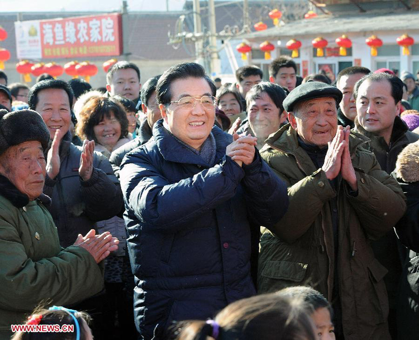 Chinese President Hu Jintao (C) watches 'Flower Is A Go-Between', a traditional opera, along with residents of Tianxianyu Village in the Huairou District of Beijing, capital of China, Jan. 22, 2012. Hu visited grassroots urban and rural areas in Beijing on Sunday, the eve of the Spring Festival, extending greetings to the people and celebrating with them the Chinese Lunar New Year.