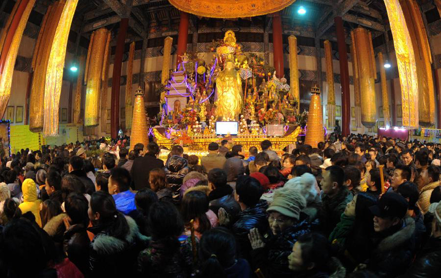 People gather in a sanctuary at Kaifu Temple to pray in front of Buddhas for divine blessings in Changsha, capital of central China's Hunan Province, on Jan. 23, 2012, the first day of the Chinese lunar Year of Dragon. Kaifu Temple was one of the famous Buddhism resort which enjoys over one thousand years of history.