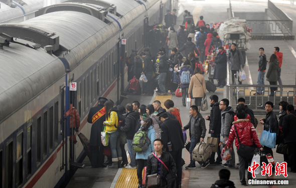 Passengers line up for getting on the train in Beijing West Railway Station on Jan. 19. 