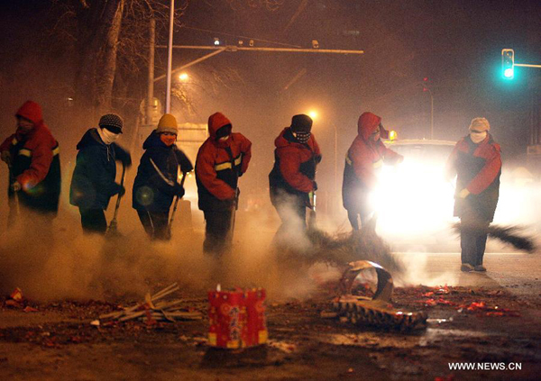 Sanitation workers clean the firecracker residue on a street in Beijing on Jan. 23, 2012. A good deal of firecrackers has been set off on the eve before Spring Festival as a kind of Chinese folk tradition.