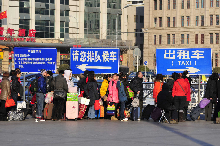 Passengers queue up to take taxis near the Beijing Railway Station in Beijing, capital of China, Jan. 26, 2012. Railway terminals in major Chinese cities are braced for a new travel rush, as millions of travelers are returning to city work near the end of the week-long Spring Festival holiday.