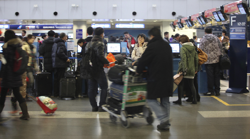 Passengers prepare to check in for their flights at the Beijing Capital International Airport in Beijing, capital of China, Jan. 26, 2012. China is braced for a new travel rush, as millions of travelers are returning to city work near the end of the week-long Spring Festival holiday. 