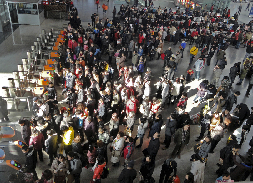 Passengers wait to board trains at the Suzhou Railway Station in Suzhou, east China's Jiangsu Province, Jan. 26, 2012. Railway terminals in major Chinese cities are braced for a new travel rush, as millions of travelers are returning to city work near the end of the week-long Spring Festival holiday.