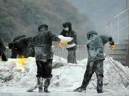 Firefighters work to put in chemicals made from dissolved aluminum chloride to neutralize the polluted Longjiang River in Hechi City, south China's Guangxi Zhuang Autonomous Region, Jan. 26, 2012.