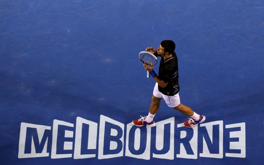 Djokovic walks past the Australian Open logo &apos;Melbourne&apos; after beating Nadal to retain the men&apos;s open champion at the Australian Open on Sunday. [Xinhua]