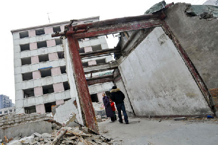 Liang's 'siheyuan,' the traditional courtyard home, was demolished to piles of rubble surrounding a lone wooden gate. [Xinhua] 
