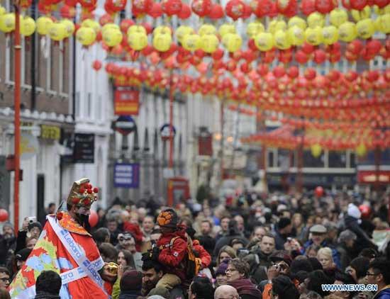 A man dressed as the Chinese money god delivers well-wishes to people on a street of the London Chinatown in central London, Jan. 29, 2012. [Xinhua] 