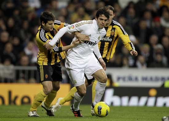 Real Madrid's Kaka from Brazil, center, gets between Zaragoza's Javier Paredes, left, and Timislav Dujmovic from Croatia, right, during a Spanish La Liga soccer match at the Santiago Bernabeu stadium in Madrid, Saturday, Jan. 28, 2012. 