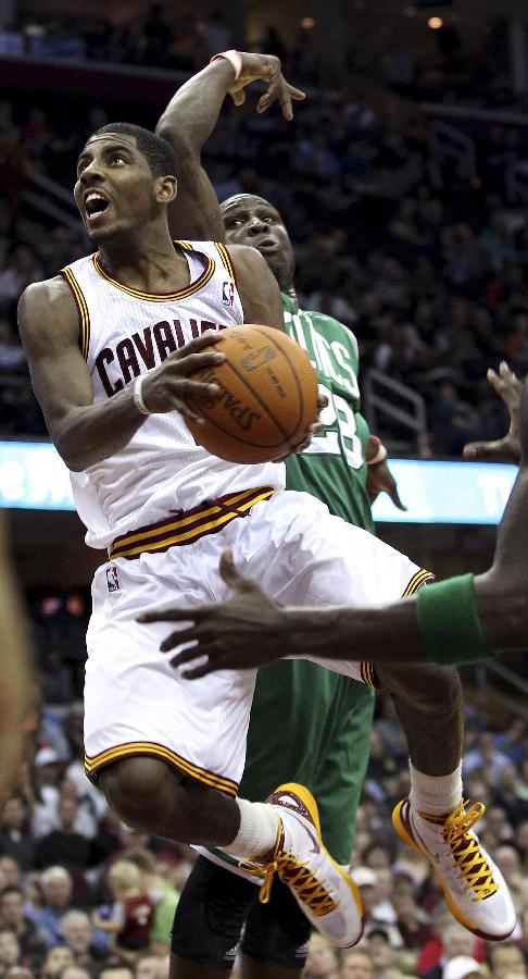 Cleveland Cavaliers' rookie Kyrie Irving (L) glides through the air to put up a shot past Boston Celtics' defender Mickael Pietrus (R) during the fourth quarter of their NBA basketball game in Cleveland January 31, 2012. Celtics won 93-90. (Xinhua/Reuters Photo) 