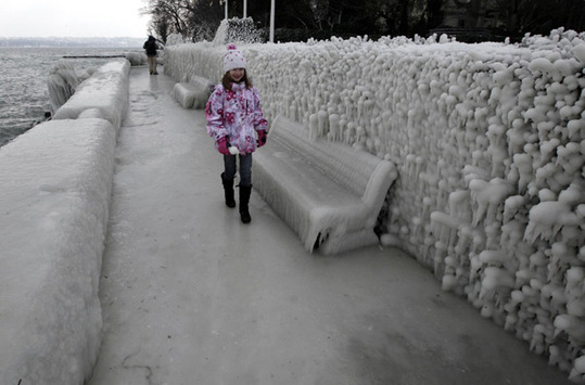 A girl walks on the ice covered pavement along the bank of Leman Lake in Versoix near Geneva February 5, 2012.  [Photo/Agencies] 
