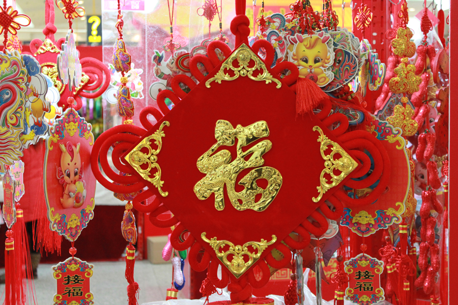 A Chinese knot with Chinese character 'fu,' which means good luck, blessings, happiness and good fortune, is on display in an indoor temple fair in the Golden Resources Shopping Mall located in the northwest part of Beijing during the Spring Festival 2012, where visitors can enjoy the charm of the traditional Chinese arts and the delicacy of local snacks. [By Xu Lin / China.org.cn]