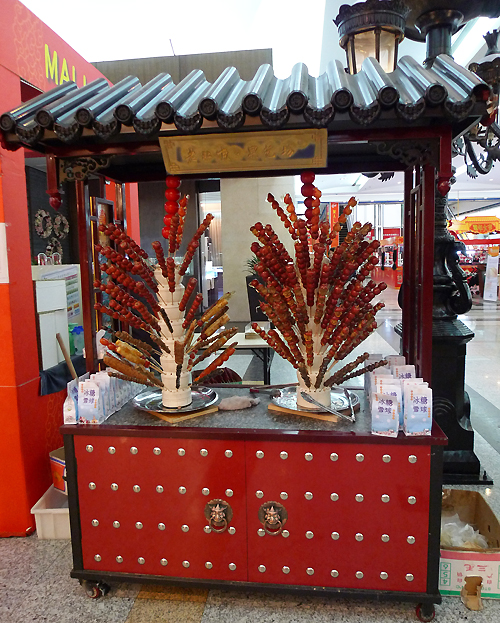 Sugar-coated fruits on a stick, a traditional Beijing snack, are on sale in an indoor temple fair in the Golden Resources Shopping Mall located in the northwest part of Beijing during the Spring Festival 2012, where visitors can enjoy the charm of the traditional Chinese arts and the delicacy of local snacks. [By Xu Lin / China.org.cn]