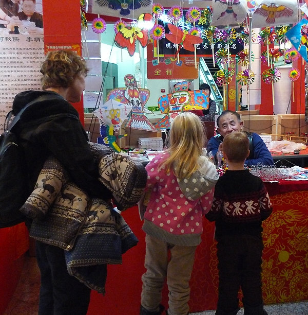 Foreign visitors are interested in the commodities on display in an indoor temple fair in the Golden Resources Shopping Mall located in the northwest part of Beijing during the Spring Festival 2012, where visitors can enjoy the charm of the traditional Chinese arts and the delicacy of local snacks. [By Xu Lin / China.org.cn]