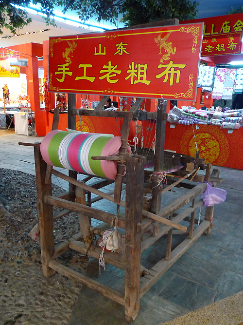 A loom is on display in an indoor temple fair in the Golden Resources Shopping Mall located in the northwest part of Beijing during the Spring Festival 2012, where visitors can enjoy the charm of the traditional Chinese arts and the delicacy of local snacks. [By Xu Lin / China.org.cn]