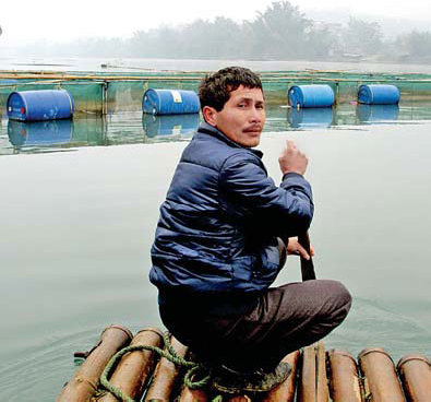 A villager checks stocks in his fish farm in Yizhou, South China's Guangxi Zhuang autonomous region, on Wednesday. Cadmium leaked from a factory into the Longjiang River where his fish farm is located. [China Daily] 